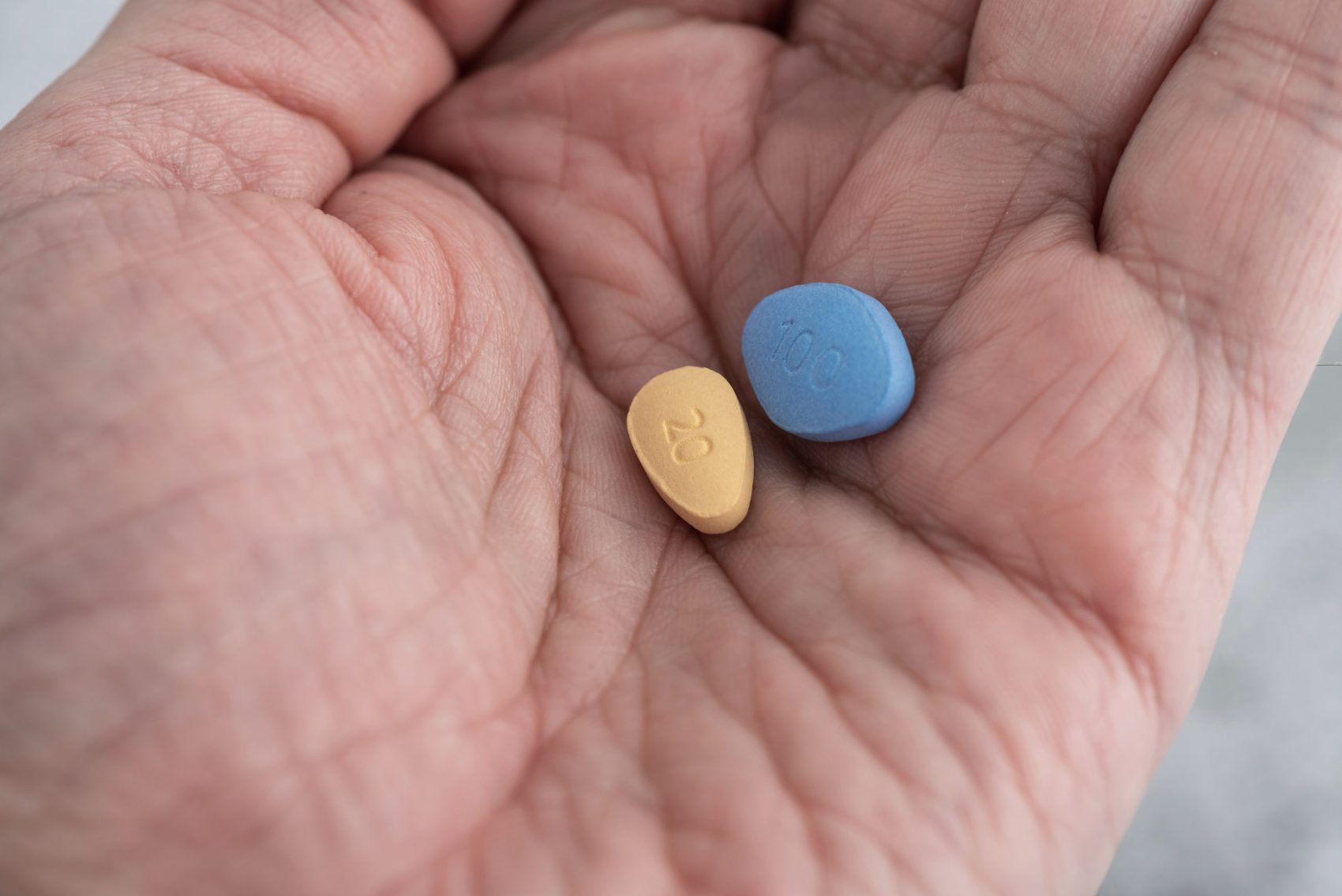 Cialis and Viagra pills in a hand comparing onset, duration, and lifestyle fit for men with ED